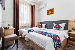 a hotel room with two beds and a window at Solief Hotel in Tashkent