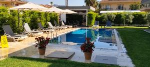 a swimming pool with chairs and umbrellas in a yard at Tanem Suit in Kemer