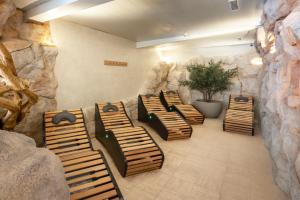 a row of benches in a room with a rock wall at Salles Hotel Aeroport de Girona in Riudellots de la Selva