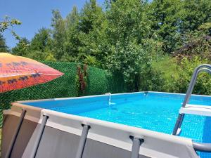 a swimming pool with an umbrella and an umbrella at FortUNA Holiday Home in Bihać