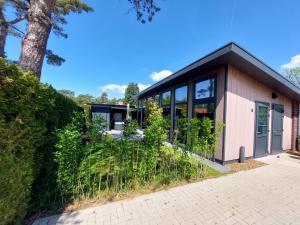 a house with a black roof at Comfort bungalow 02 met jacuzzi in Putten
