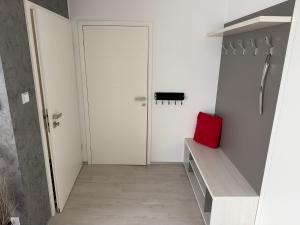 a hallway with a white door and a red pillow at La Brloh Pardubice in Pardubice