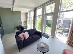 a living room with a couch and a table at Comfort bungalow 02 met jacuzzi in Putten