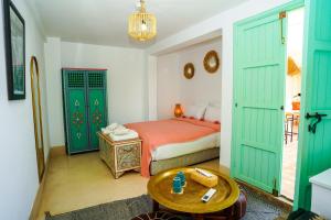 a bedroom with green doors and a bed and a table at Riad Dar Rabiaa in Rabat +190 photos