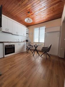 a kitchen with white cabinets and a table and chairs at Guest house LORA in Gabrovo