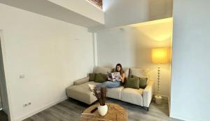 a woman sitting on a couch in a living room at Password to Madrid Gran Vía in Madrid