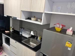 a small kitchen with a sink and a refrigerator at Sukhumvit​ 101 in Phra Khanong