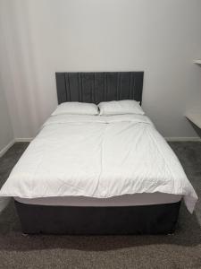 a bed with white sheets and pillows in a bedroom at Glasgow Airport in Glasgow
