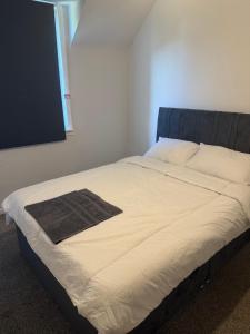 a large bed in a bedroom with a large white bedsheet at Glasgow Airport in Glasgow