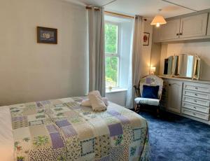 a bedroom with a bed and a chair and a window at 2 Bedroom Cottage By Cozy Quarters Property Management Holiday Lets Wolsingham Near River Waskerley in Wolsingham