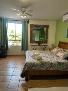 a bedroom with a bed and a mirror and a window at Kaa Zihil Hotel in Playa del Carmen