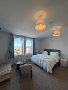 a bedroom with a large bed and two windows at Nova Rooms in Thirsk +18 photos