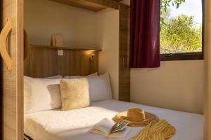 a bed with a hat and a book on it at L'Escale Royale Torcy - Marne la Vallée in Torcy +51 photos
