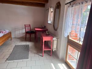 a room with two red tables and chairs and a window at Adler Stetten ob Lontal in Niederstotzingen