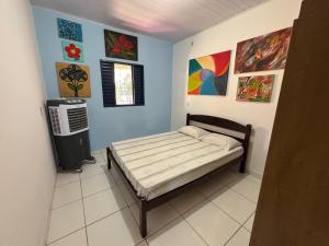 a bedroom with a bed and paintings on the wall at Casa da Santa Marta in Goiás