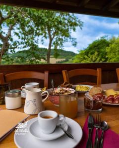 a table with a cup of coffee and a plate of food at Agriturismo La Valle del Vento Urbino in Urbino