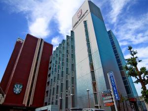 a tall building with a sign on top of it at Hotel Sunroute Aomori in Aomori