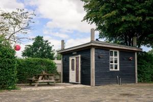 a small shed with a picnic table next to it at Chalet - Camping 't Dekske in Wintelre