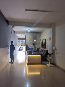 a man is standing in a living room at Hoysal Grand in Bangalore