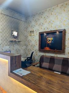 a room with a couch and a television on the wall at Hoysal Grand in Bangalore