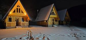 a group of cottages in the snow at night at BB CHALET in Kolašin