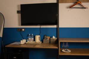 a tv on top of a shelf with bottles and glasses at Lake side Dilijan in Dilijan