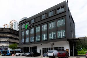 a hotel building with cars parked in a parking lot at T Plus Hotel Bagan in Butterworth