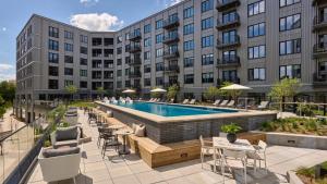 Außenansicht eines Hotels mit Pool, Tischen und Stühlen in der Unterkunft AVE Normandy - Extended Stay Furnished Apartment in Philadelphia