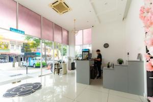 a man standing at a counter in a store lobby at T Plus Hotel Bagan in Butterworth