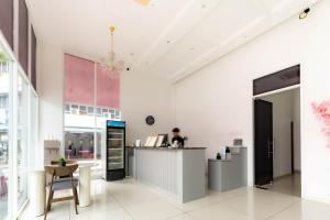 a lobby of a store with a person sitting at a counter at T Plus Hotel Bagan in Butterworth