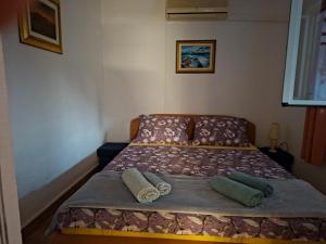 a bed in a bedroom with two pillows on it at Sandra Apartmani 3 in Zaostrog