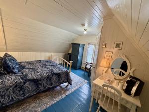 a bedroom with a bed and a table with a mirror at Maison Hovington in Tadoussac