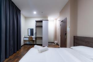 a bedroom with two beds and a desk and a television at T Plus Hotel Bagan in Butterworth +34 photos