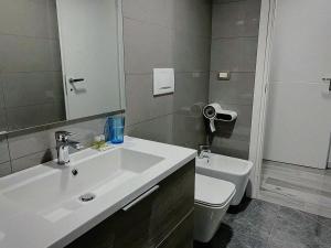 a bathroom with a white sink and a toilet at ANMAN HHBB tourism & business rooms in Padova +12 photos