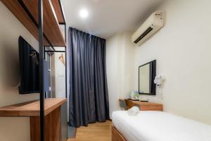 a bedroom with a bed and a tv and a mirror at T Plus Hotel Bagan in Butterworth