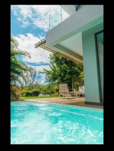 a swimming pool in front of a house at Seafront apartment in Grande Gaube