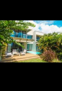 a house with two chairs and a swimming pool at Seafront apartment in Grande Gaube