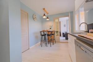 a kitchen with a counter and bar stools at La Maison Jopateliére in Mohon +17 photos