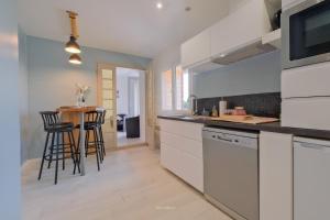 a kitchen with white cabinets and a counter top at La Maison Jopateliére in Mohon