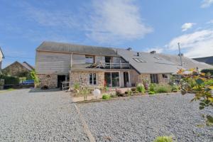 a large stone house with a gravel driveway at La Maison Jopateliére in Mohon