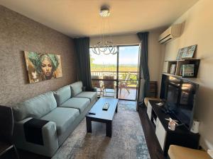 a living room with a couch and a television at Sweet home see view pool escape in Nesebar