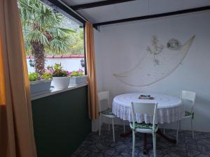 a table and chairs in a room with a window at Sandra Apartmani 3 in Zaostrog