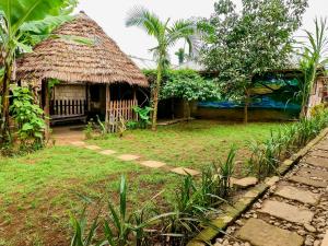 a small hut with a thatch roof and a yard at Arusha Jua Eco Home- on coffee farm in Arusha +99 photos