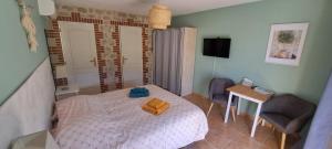 a small bedroom with a bed and two chairs at Mas Cairou in Sorède