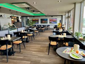 a restaurant with tables and chairs in a room at Hotel Seeblick garni in Gartow