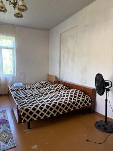 a bedroom with a bed and a fan in it at Nikola apartment ambrolauri in Ambrolauri