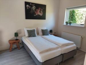 a bedroom with a bed and a window at Huisje nr. 18 met jacuzzi in Putten