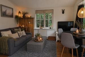 a living room with a couch and a table at Vechtdalchalet de Berk, 5 sterrenpark Capfun Stoetenslagh in Rheezerveen