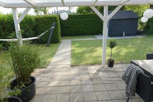 a patio with a white pergola and some plants at Vechtdalchalet de Berk, 5 sterrenpark Capfun Stoetenslagh in Rheezerveen