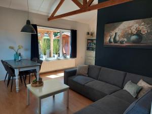 a living room with a couch and a table at Huisje nr. 18 met jacuzzi in Putten